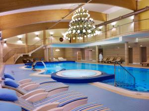 克雷尼察美居克雷尼察度假酒店 的一个带椅子和吊灯的大型游泳池