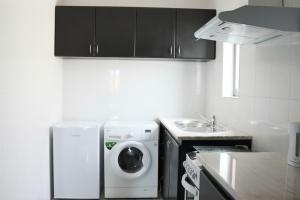 埃斯帕戈斯Apartamento Preguiça的厨房配有洗衣机和水槽