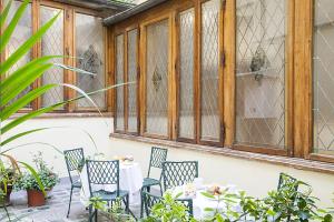 佛罗伦萨学院酒店的一个带桌椅的庭院和一个窗户。
