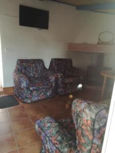 Corral de CalatravaCasa Rural La Alfarera的客厅配有2张沙发和1台平面电视