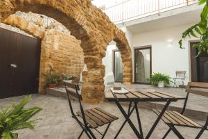 阿格里真托Cortile Baronello的一个带桌椅和砖墙的庭院