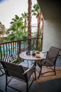 拉斯维加斯Tuscany Suites & Casino的棕榈树阳台的桌椅
