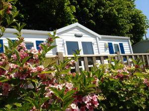 索姆河畔的圣瓦列里沃尔里克露营旅馆的粉红色花卉围栏后面的白色房子