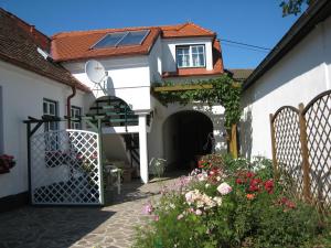 UnterretzbachWeinhof Gregor Raab的白色的房子,有门和一些花