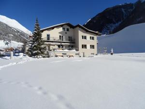 乌姆豪森Apart Tyrol的雪地中的一座建筑,有圣诞树
