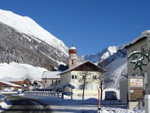 乌姆豪森Apart Tyrol的雪中带钟楼的房子