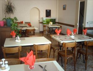 埃佩尔奈Hotel Le Colbert epernay的餐厅设有桌椅,上面有红色的弓