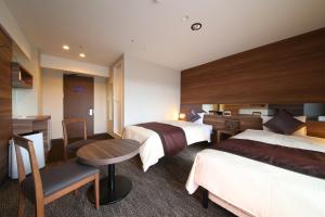 成田爱迪星大酒店的酒店客房配有两张床和一张书桌
