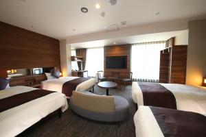 成田爱迪星大酒店的酒店客房设有三张床和电视。