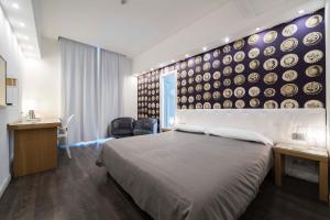 萨莱诺蒙特斯特拉酒店的一间卧室配有床,墙上挂着盘子
