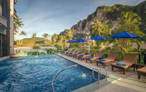 奥南海滩Andaman Breeze Resort - SHA Plus的度假村的游泳池,配有椅子和遮阳伞