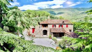 科尔托纳Borgo Solamore的山上的一座大型石屋,设有红色的门