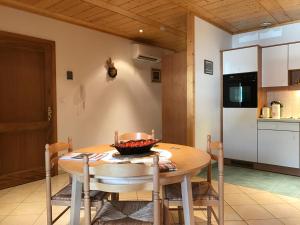 苏茨马特Les Berges de l'Ohmbach的厨房以及带木桌和椅子的用餐室。