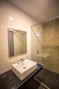 哥打京那巴鲁3-Plus Hotel的一间带水槽和玻璃淋浴的浴室