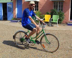 图克姆卡里Blue Swallow Motel的骑绿色自行车的人