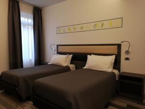 维博瓦伦蒂亚Palazzo IrMa - Hotel - B&B Luxury的一间卧室设有两张床和窗户。