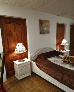 维尔纽斯Homestay Roja的一间卧室配有一张床和一张桌子上的两盏灯。