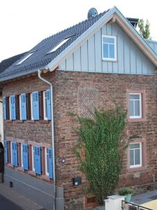 美茵河畔哈瑙Backsteinhaus Hanau的一间设有蓝色窗户和屋顶的砖屋