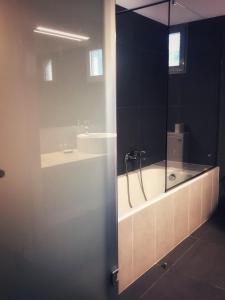 奥林匹亚莱尼达奥旅馆的带浴缸和盥洗盆的浴室