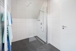 诺德奈Deniz - Blick的浴室设有白色瓷砖淋浴。