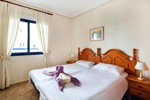卡布罗伊格Apartment Eva Cabo Roig的一间卧室配有一张床铺,床上铺有紫色毯子