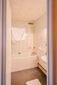 DompaireLe Commerce的白色的浴室设有浴缸和水槽。