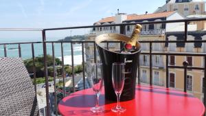 比亚里茨佛洛利达酒店的阳台上的桌子上放有一瓶香槟和两杯酒