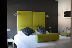科莱拉托特索姆珀普斯旅馆的一间卧室配有一张带绿色床头板的床