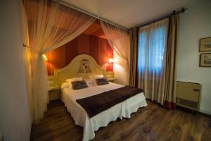 托莱多德尔卡德纳尔庄园酒店的一间卧室设有一张床和一个大窗户