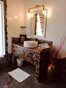 Zamboanguita白巧克力山度假村的一间带石制水槽和镜子的浴室