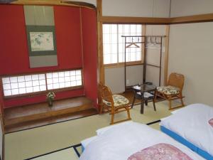 中津川市Guest House Motomiya的卧室配有一张床和一张桌子及椅子