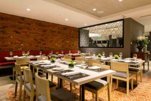 利马Mercure Ariosto Lima的一间带桌椅的餐厅以及砖墙