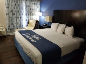 汤姆森苏格兰汤姆森汽车旅馆的酒店客房设有一张大床,上面有酒店标志