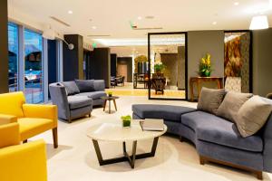 利马Mercure Ariosto Lima的客厅配有蓝色的沙发和黄色的椅子