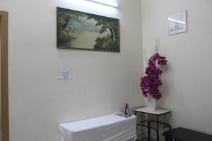 乔治市老槟城酒店 - 庄路的墙上有紫色花瓶的白色桌子