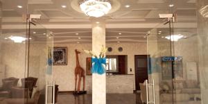 科托努Noahgarden Hotel的大厅,柱子上有一个长颈鹿
