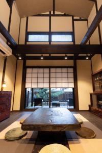 金泽Zaimoku-an的配有大窗户的客房内一张大木桌