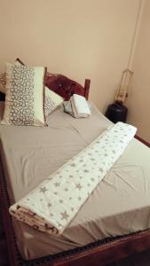 巴斯科AN Velayo Homestay (ANVEL)的一张带白色棉被和枕头的床