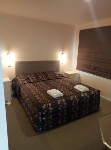 塔卡卡佩顿岩石海滩别墅的一间卧室配有一张床,上面有两条毛巾