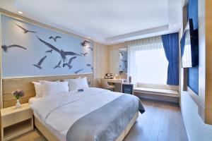 伊斯坦布尔Ramada by Wyndham Istanbul Old City的卧室配有一张大床,墙上有鸟
