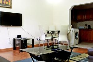 利隆圭Avon Apartments的客厅配有桌椅和电视。