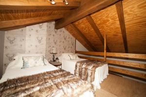 Las Cruceras阿鲁拉斯古努克欧图里莫酒店的配有木天花板的客房设有两张床。