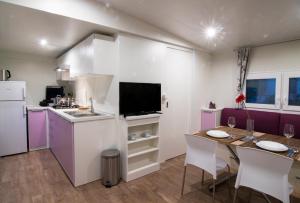 波雷奇CHERRY Premium ADRIA Mobile homes Zelena Laguna的一间带桌子的厨房和一间带紫色的厨房