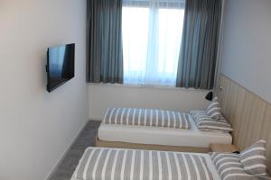 弗莱堡Hotel Lumi的小房间设有两张床和电视