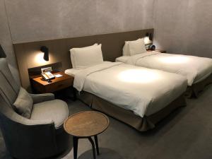 台北雀客旅馆台北南京的酒店客房,配有两张床和椅子