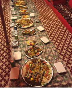 乌姆莱季Royal Tours Permanent Camp的一张长桌,上面放着许多盘子的食物