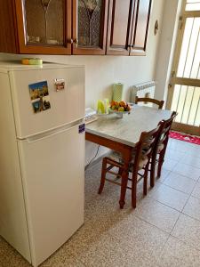 CerenziaFra il MARE e la SILA的厨房配有桌子和白色冰箱。