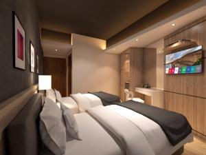 新山Grand Hallmark Hotel - Johor Bahru的一间卧室配有四张白色的床和一台平面电视