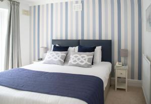 布里克瑟姆贝瑞海德酒店的一间卧室配有一张蓝色和白色条纹的床