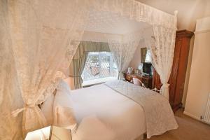埃文河畔斯特拉特福弗吉尼亚旅馆的卧室配有白色的床和窗户。